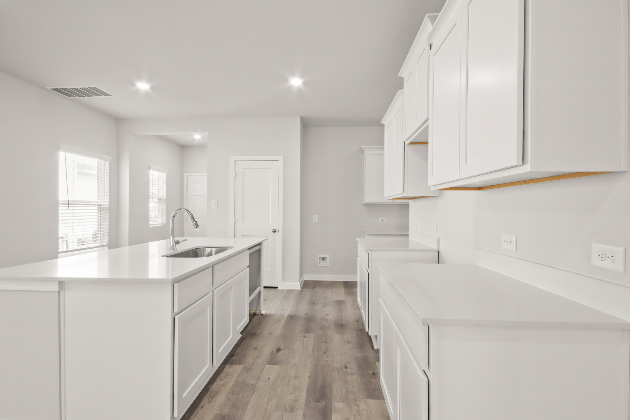 A kitchen with white cabinets.
