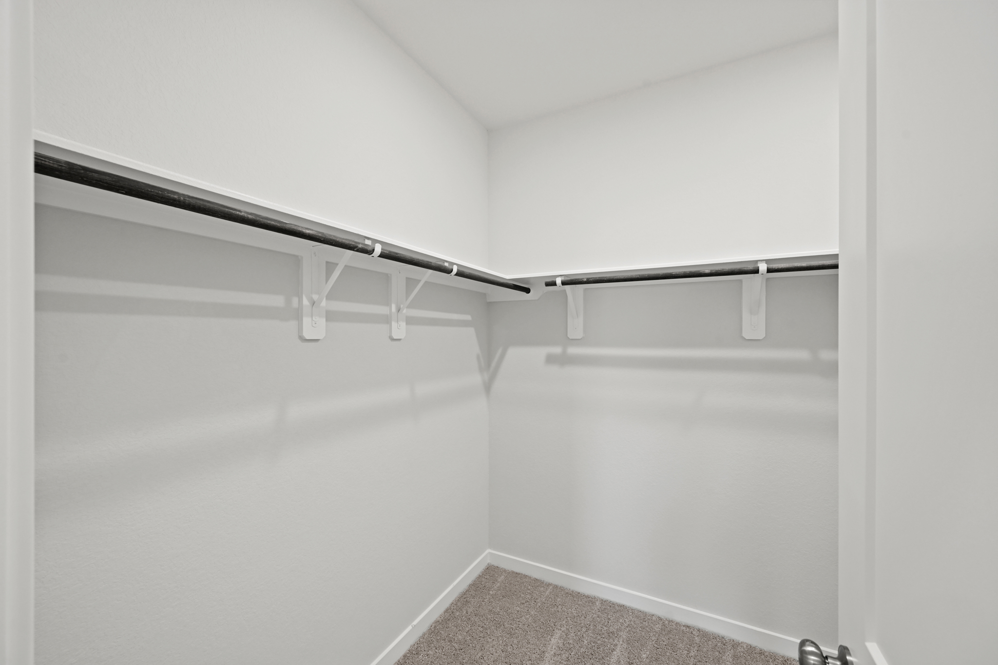 A white wall with a metal bar.