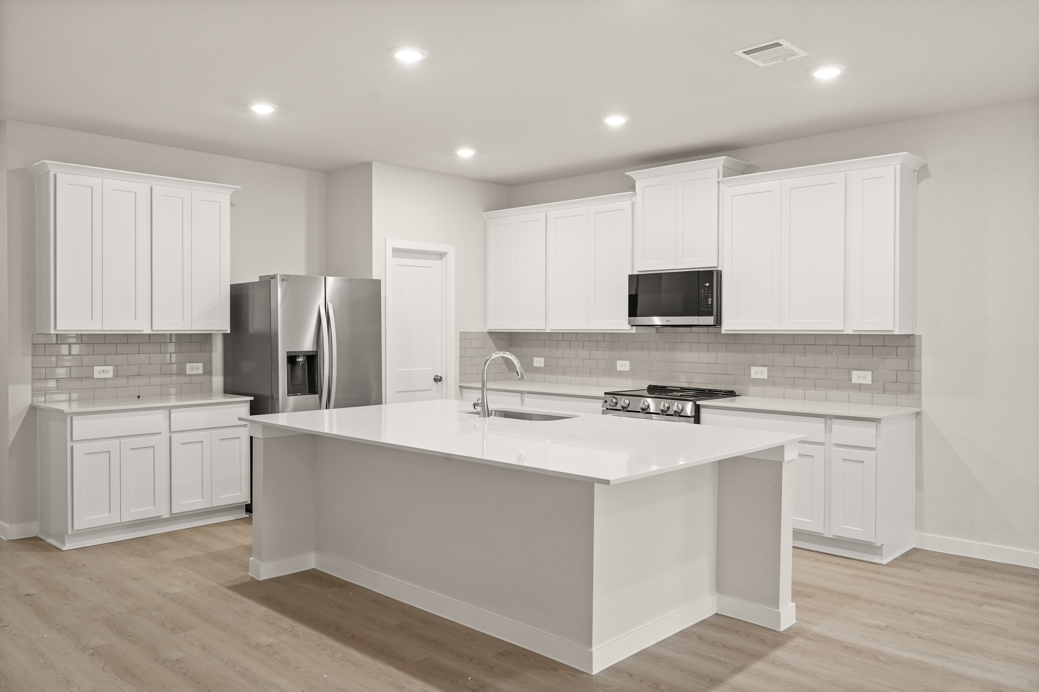 A kitchen with white cabinets.
