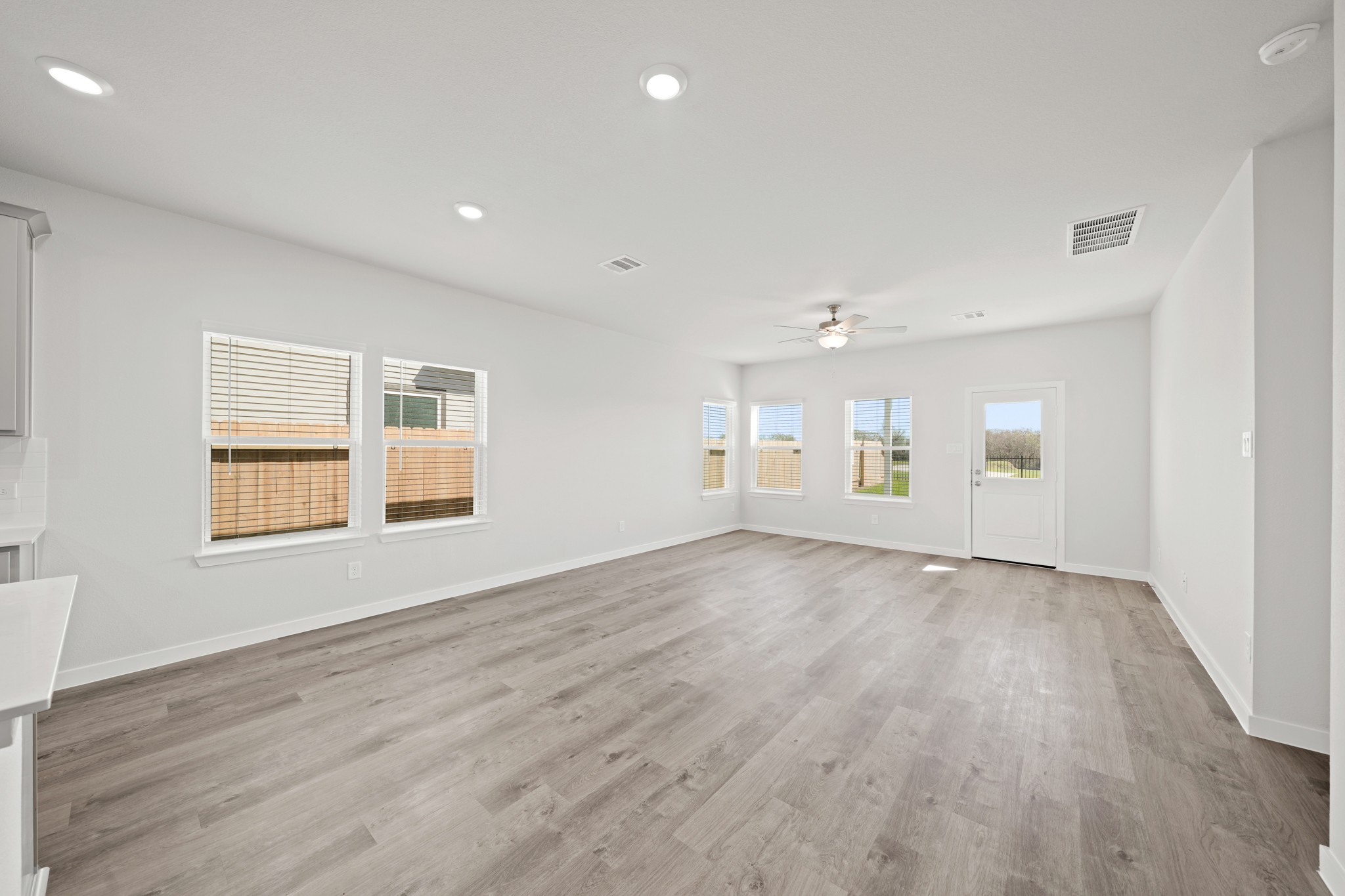 A room with a wood floor and windows.