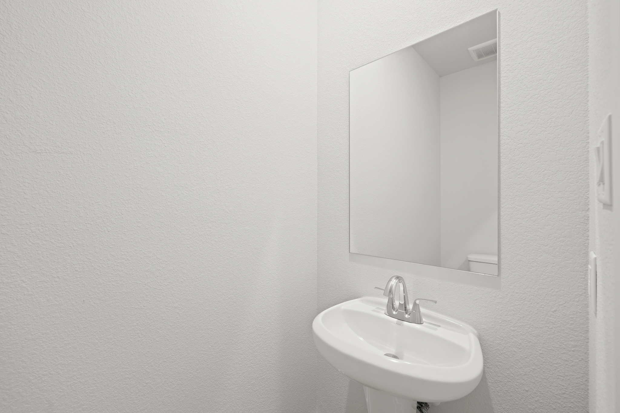 A bathroom with a large mirror.