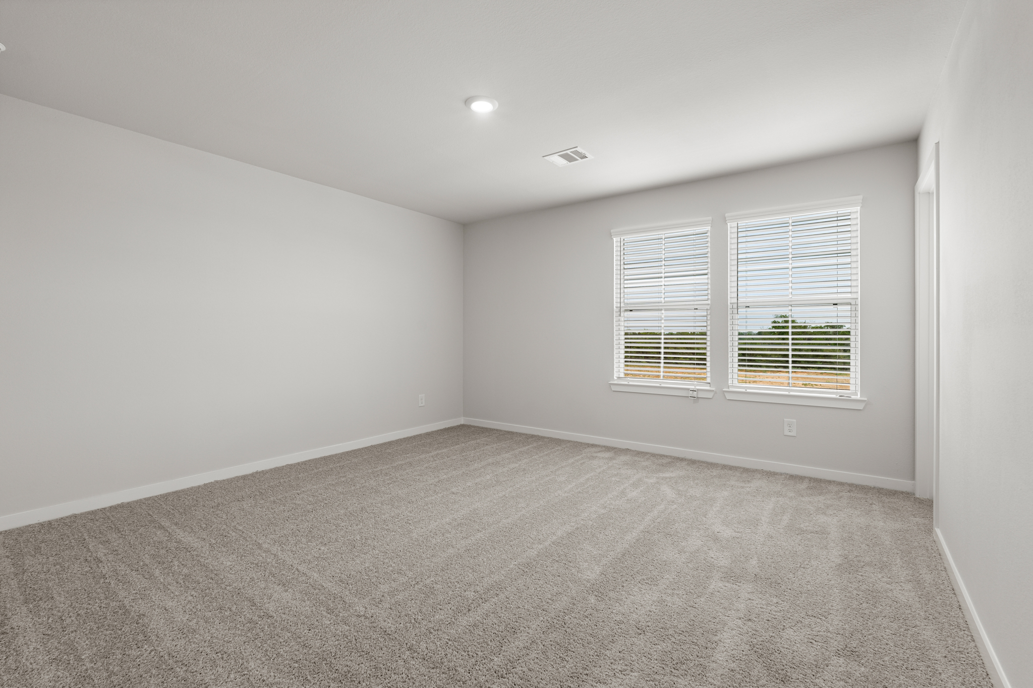 A room with a window and a carpet.