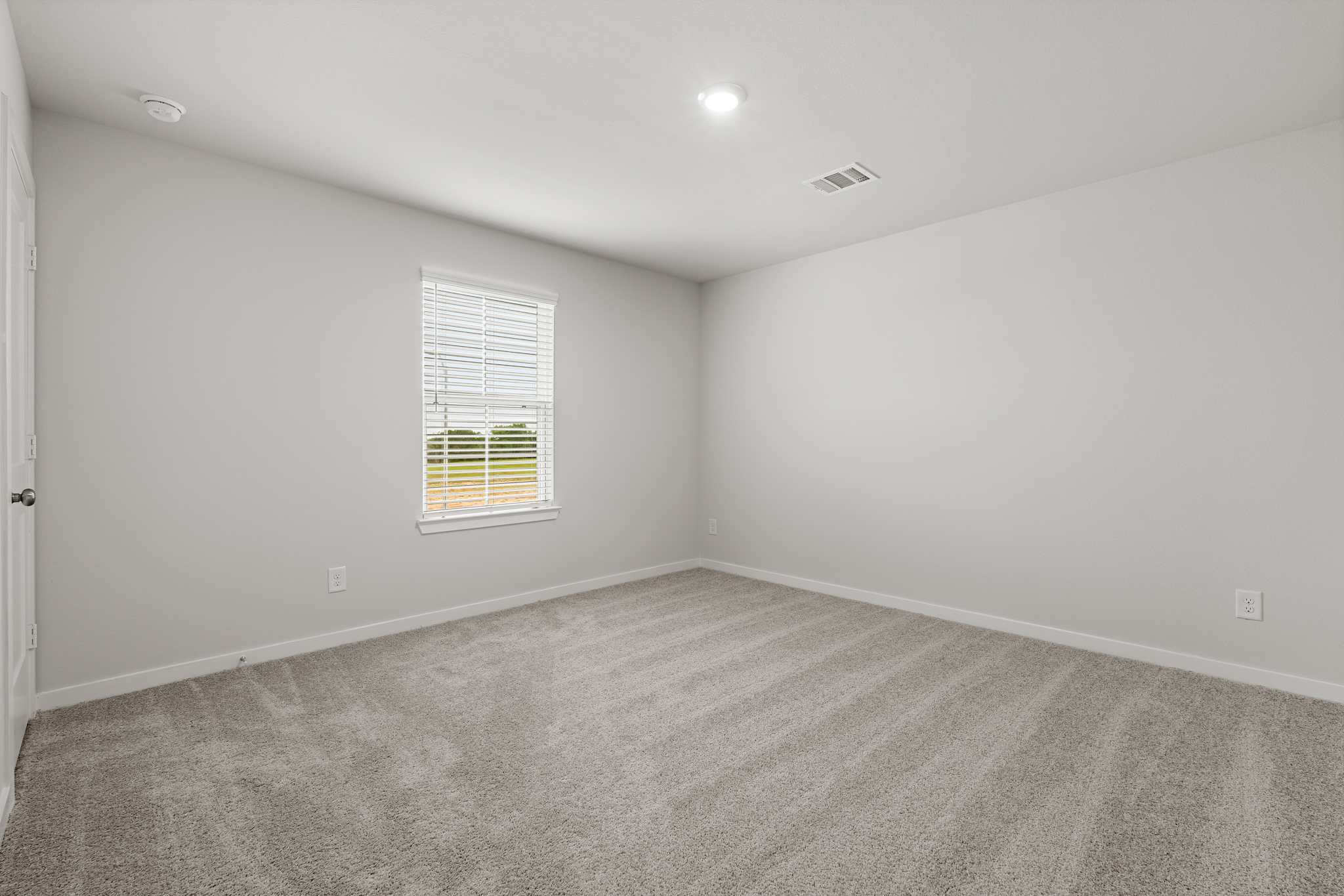 A room with a window and carpet.