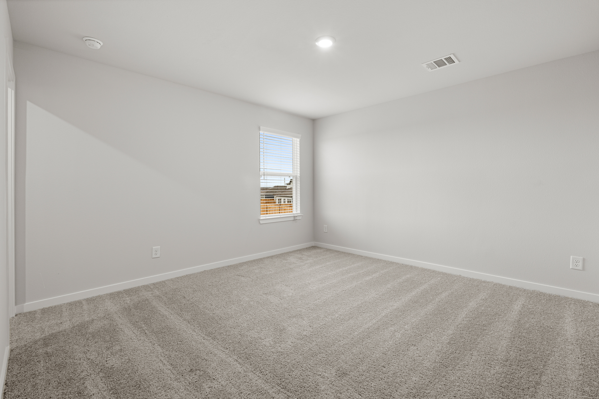 A room with a carpet and a window.
