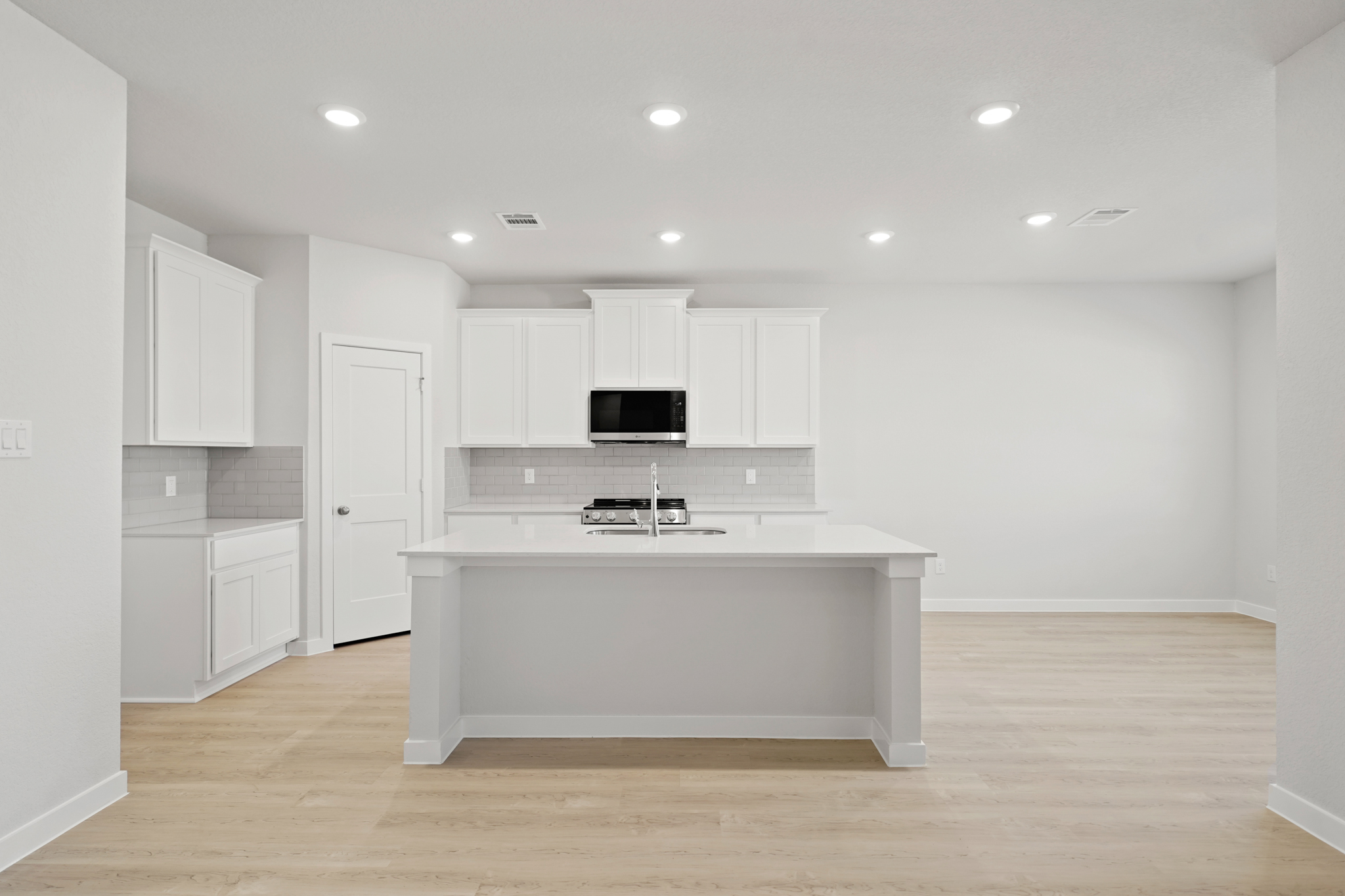 A kitchen with white cabinets.