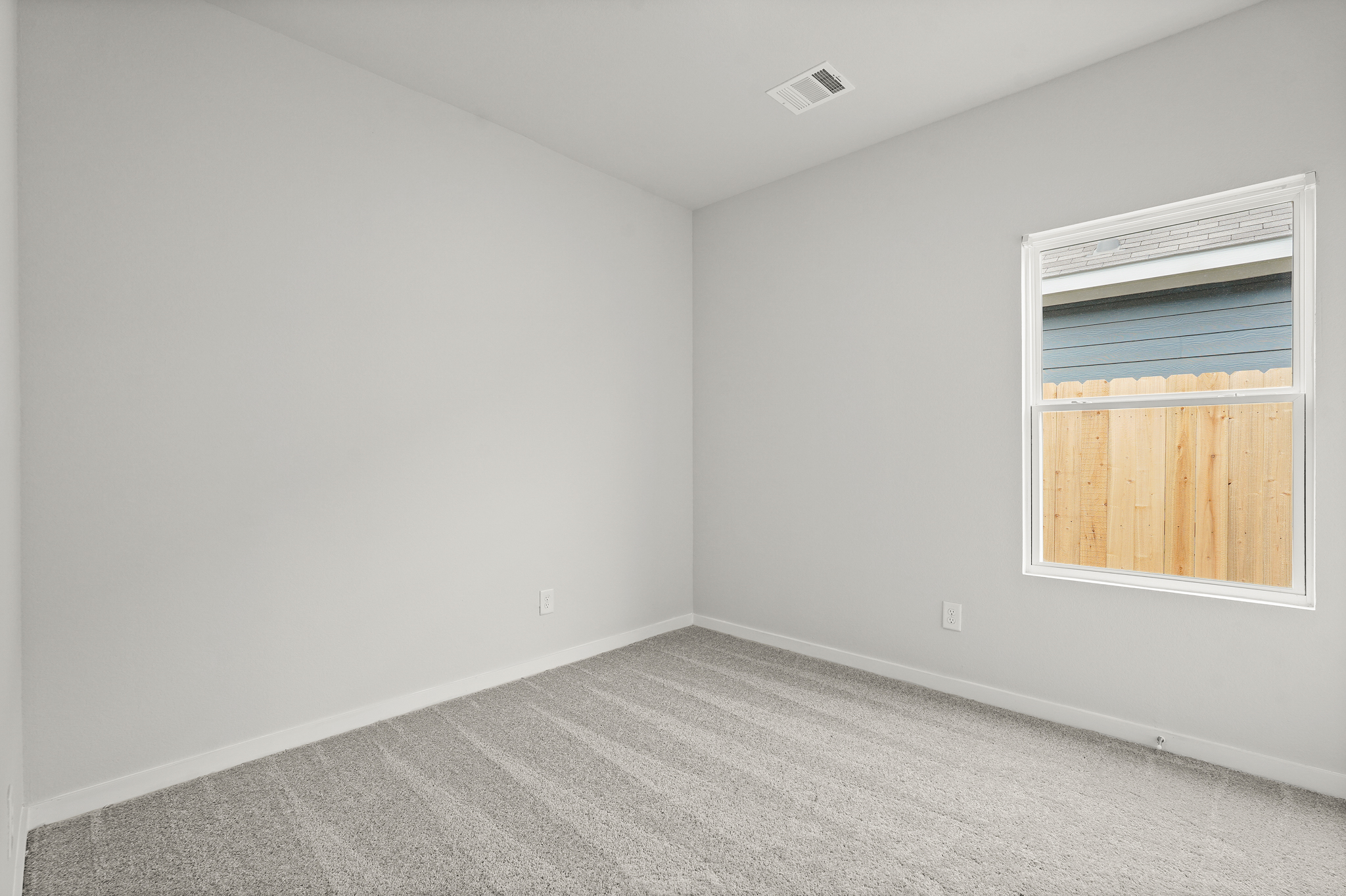 A room with a window and a carpet.