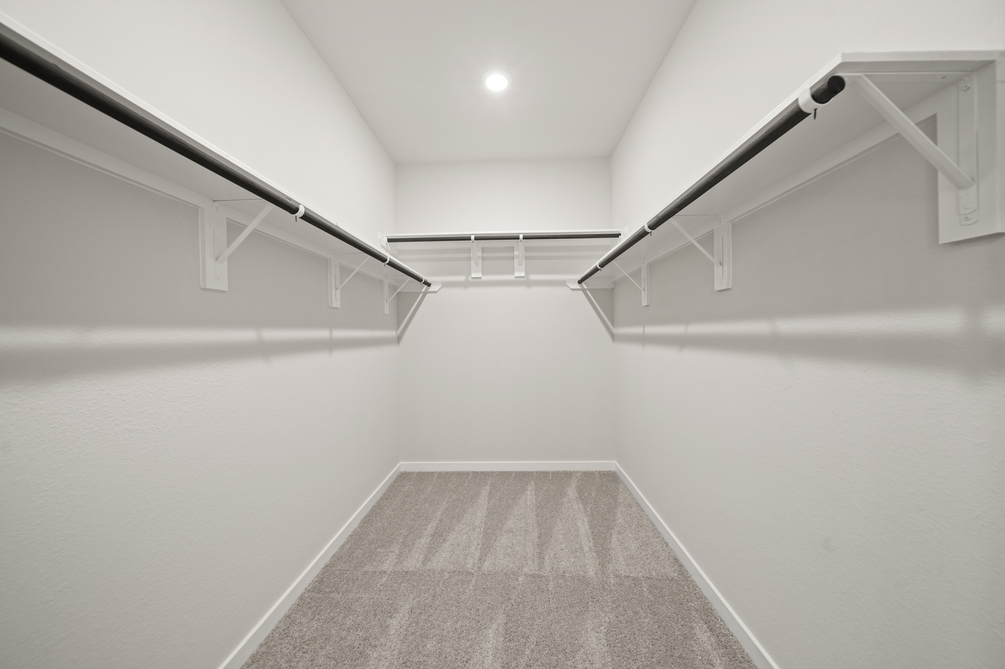 A white hallway with a grey carpet.