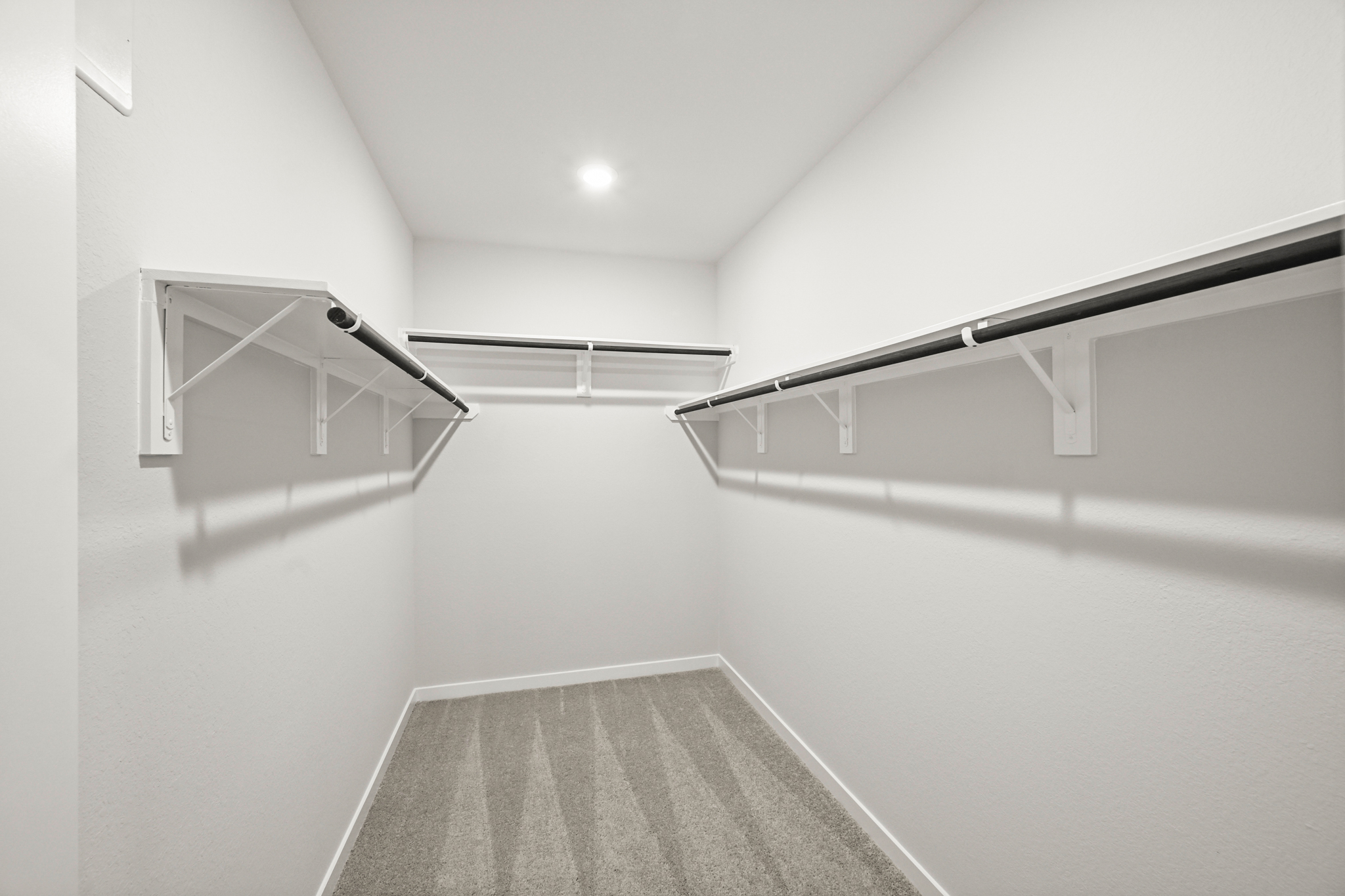 A white hallway with a metal railing.