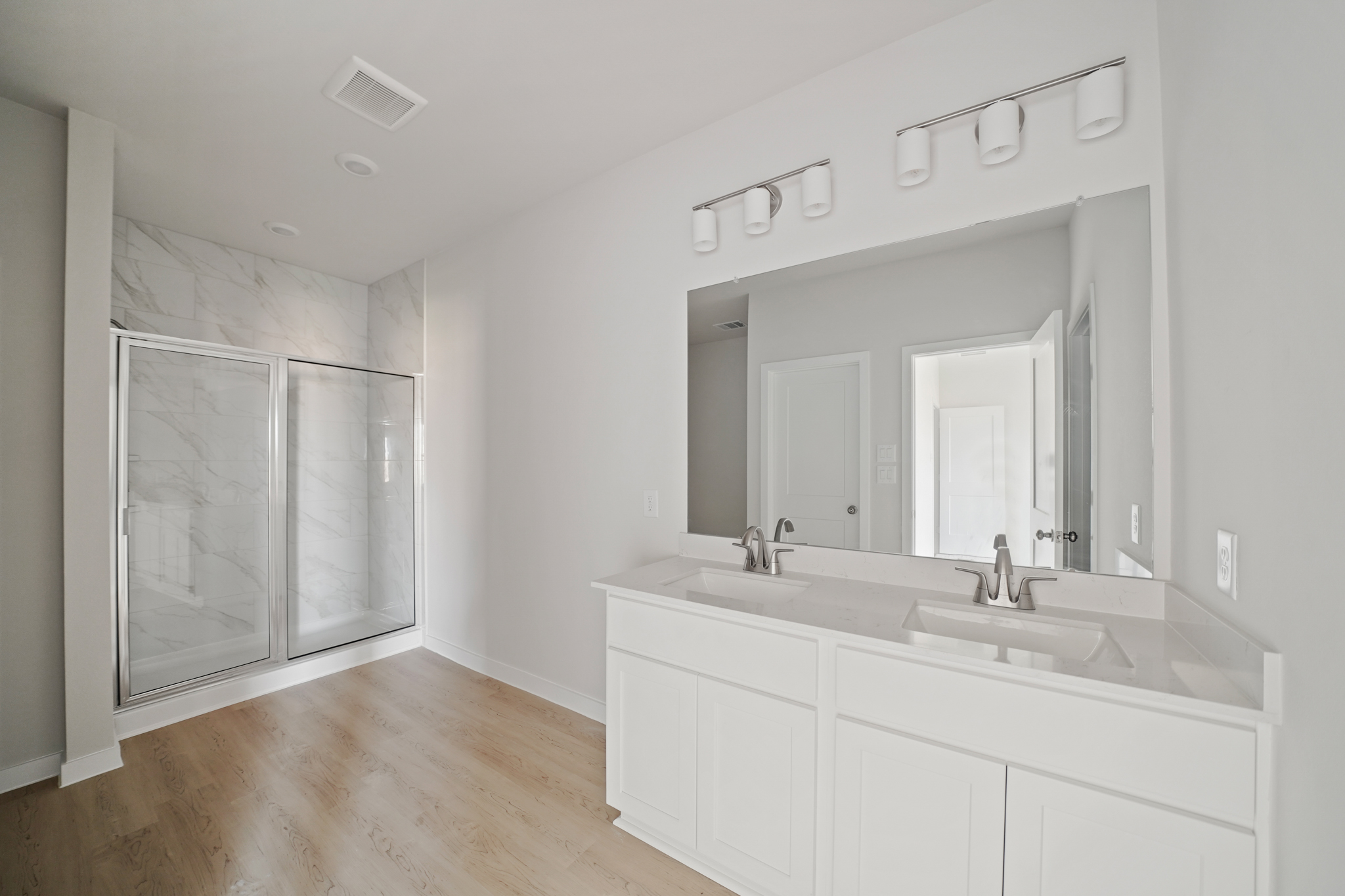 A bathroom with white cabinets.