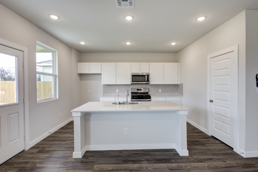 A kitchen with white cabinets.