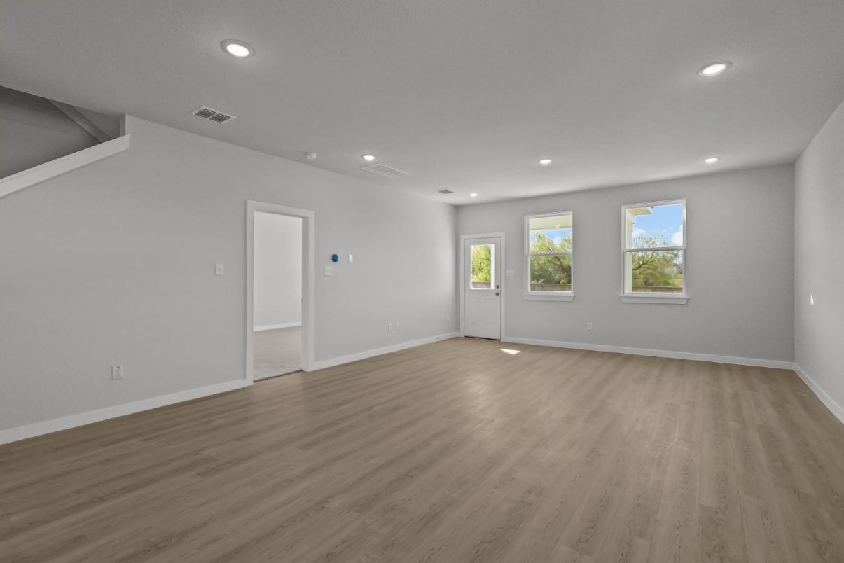A room with a wood floor and windows.