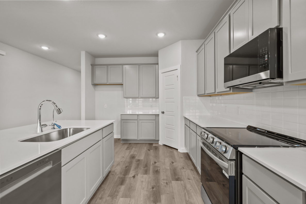 A kitchen with white cabinets.