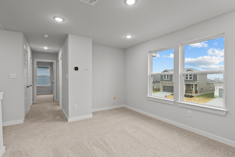A room with a window and a door with a view of the ocean.