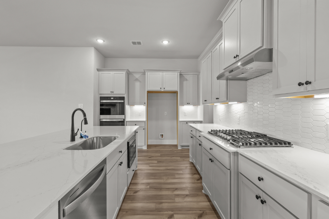 A kitchen with white cabinets.