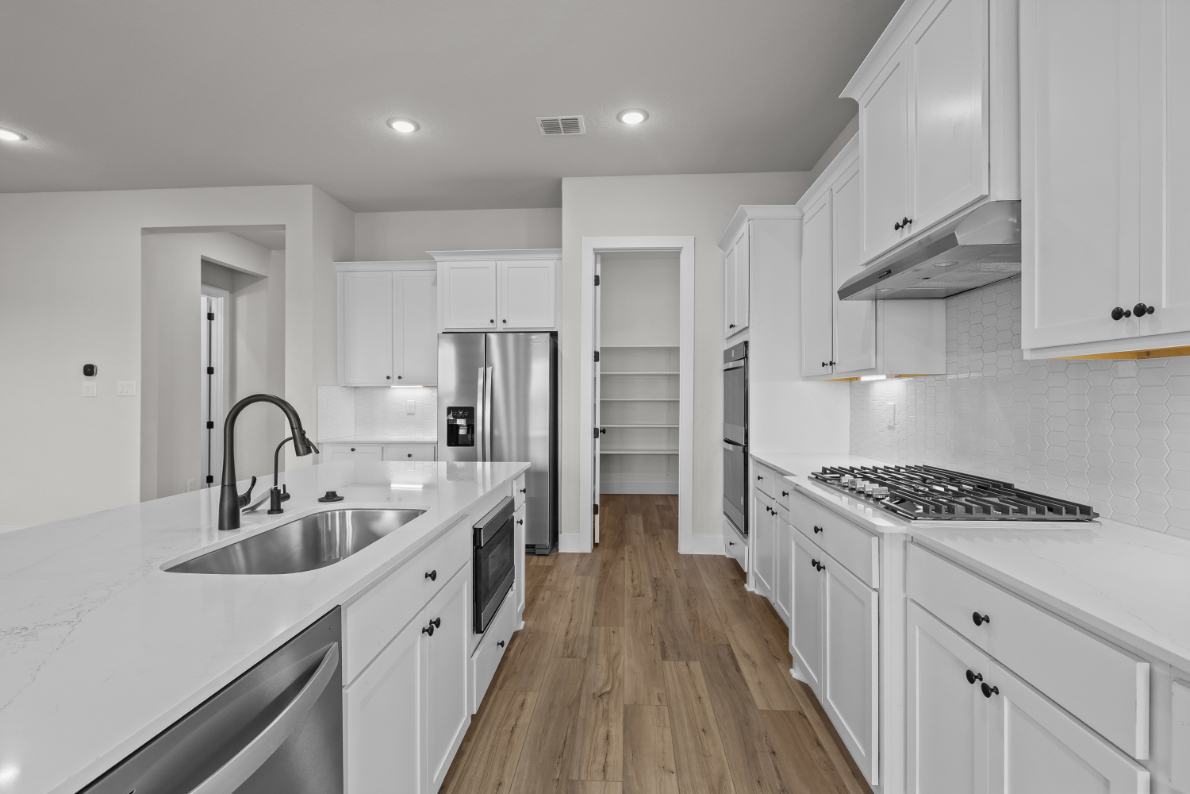 A kitchen with white cabinets.