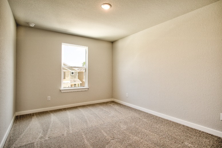 A room with a window and carpet.