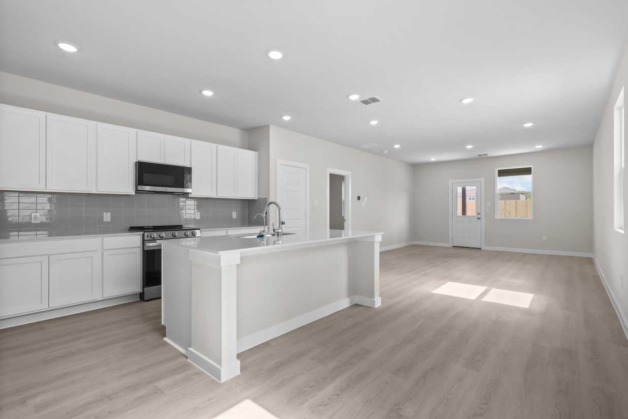 A kitchen with white cabinets.