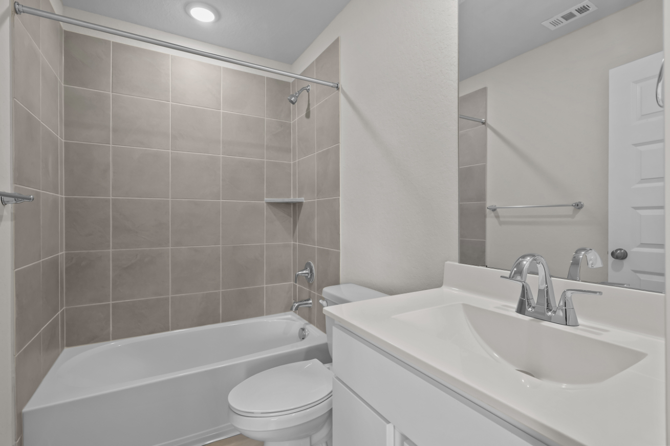 A bathroom with a tub sink and toilet.