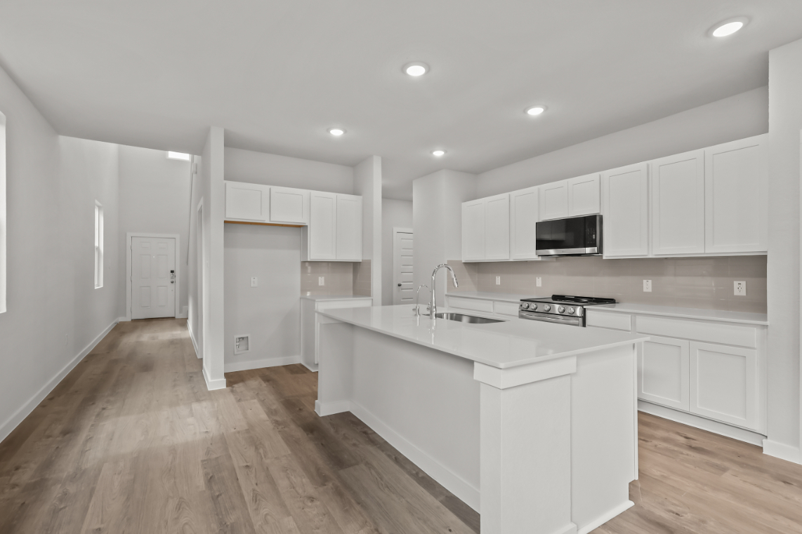A kitchen with white cabinets.