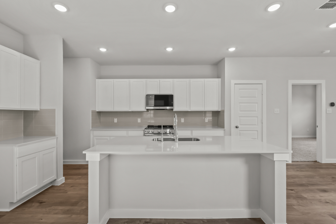 A kitchen with white cabinets.
