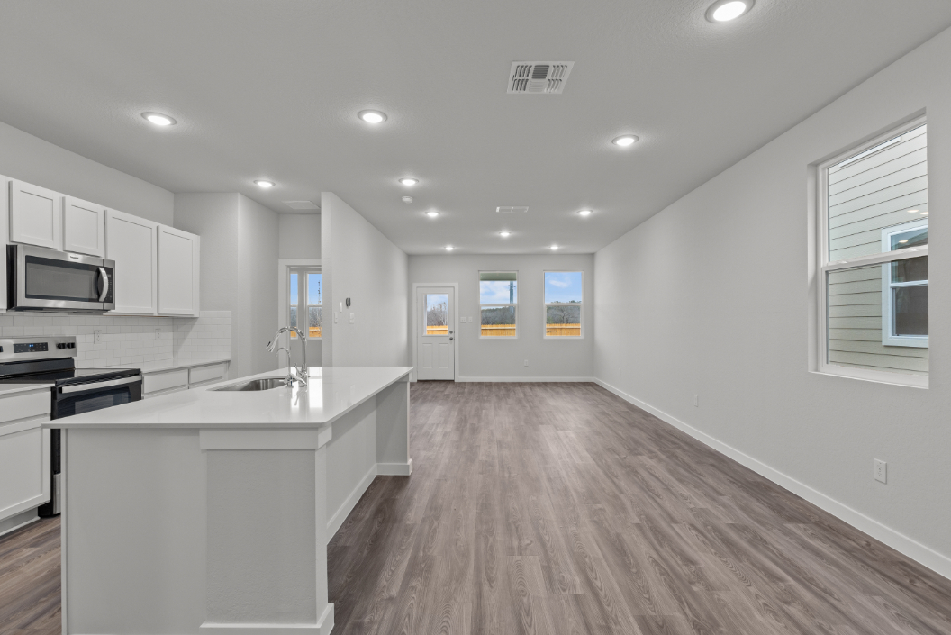 A kitchen with white cabinets.