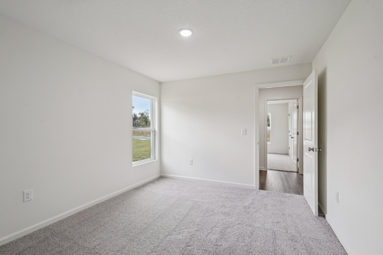 A room with a carpet and a window.