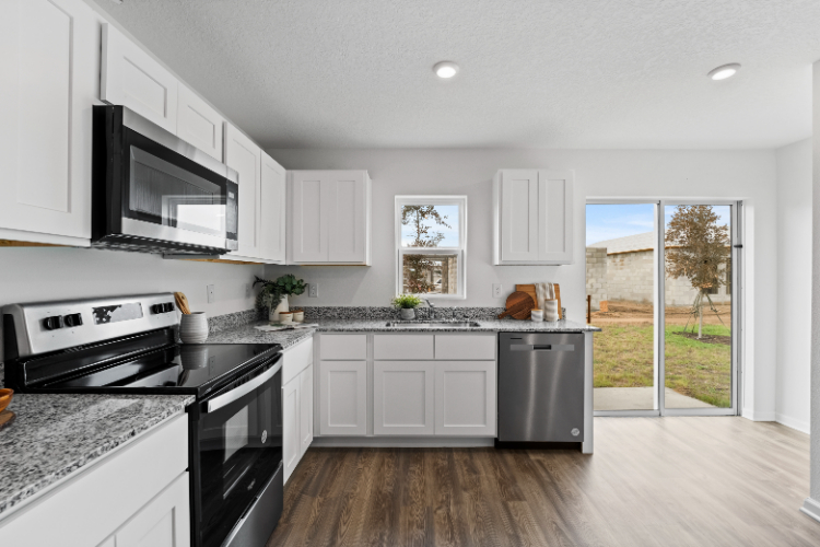 A kitchen with white cabinets.