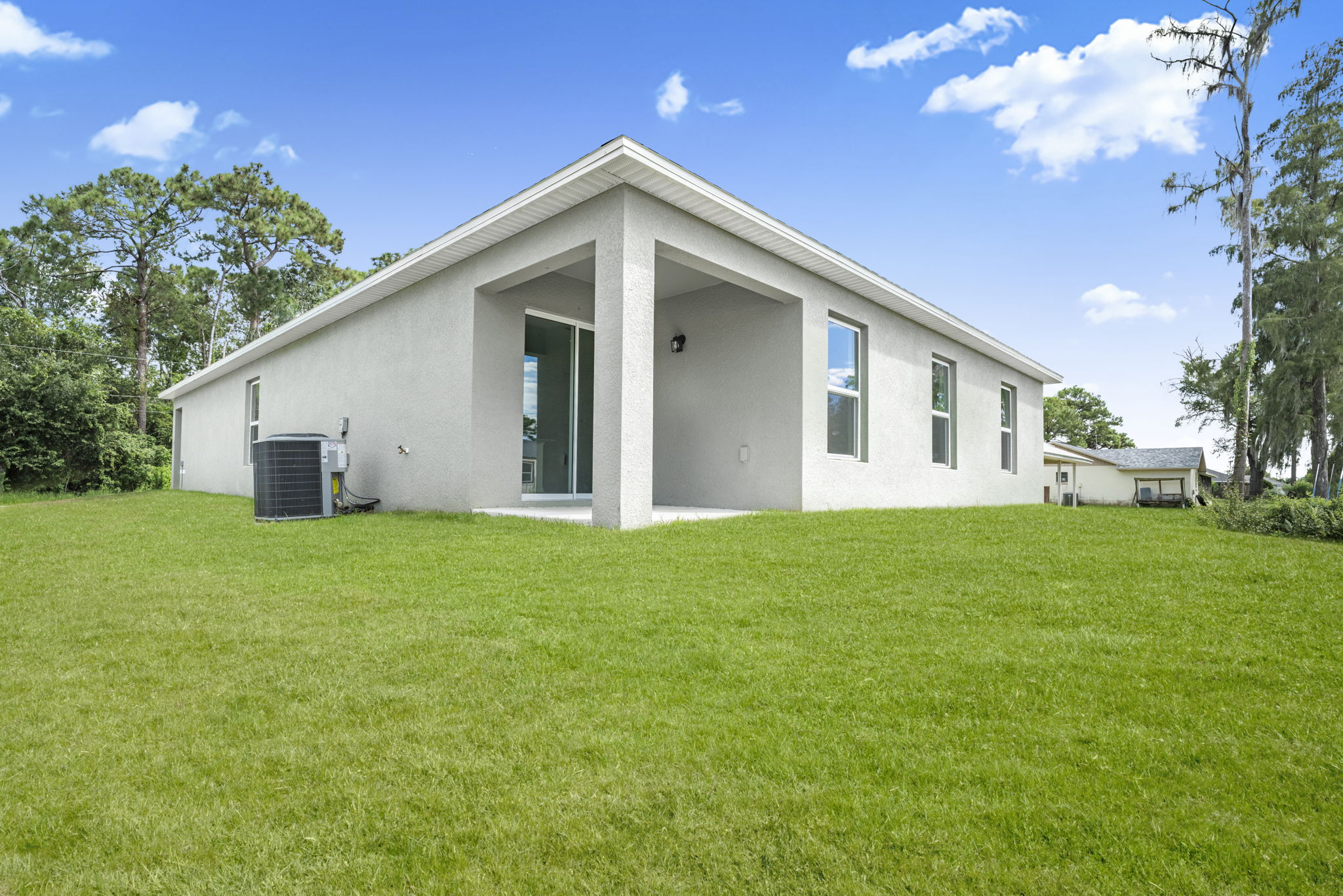 A white house with a green lawn.