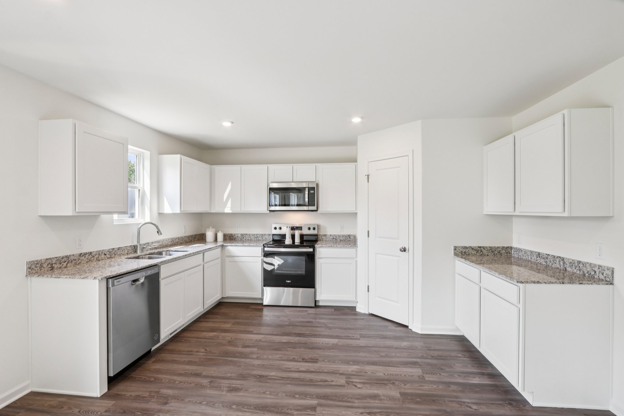 A kitchen with white cabinets.
