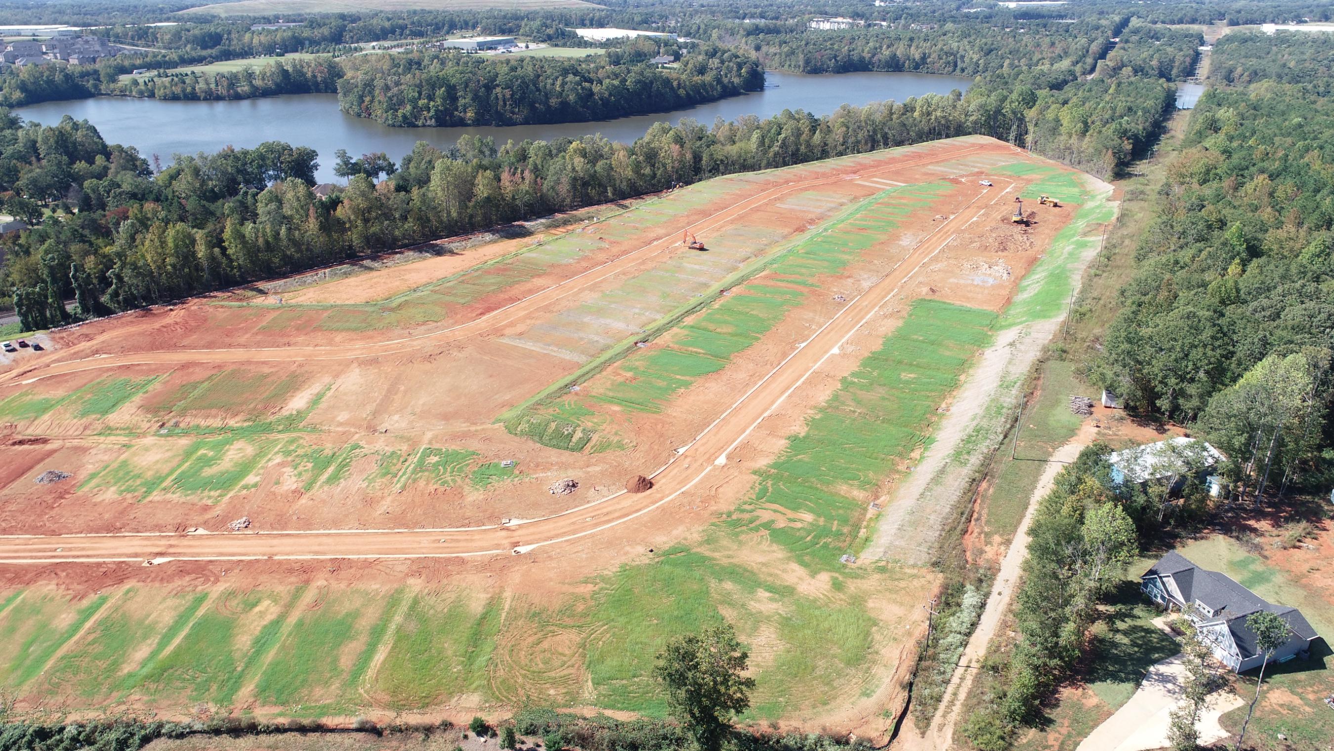 A large green field with a river running through it.